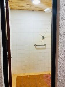 a bathroom with a shower with white tiles at Las Azaleas in Puerto Iguazú