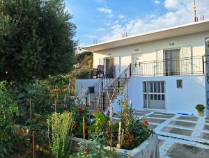 a white house with a staircase in front of it at Ermioni Gialova in Gialova