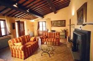 a living room with two chairs and a television at Terre di Nano in Monticchiello