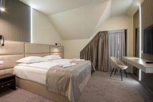 a hotel room with a large bed and a desk at Rarău Retreat in Câmpulung Moldovenesc +191 photos
