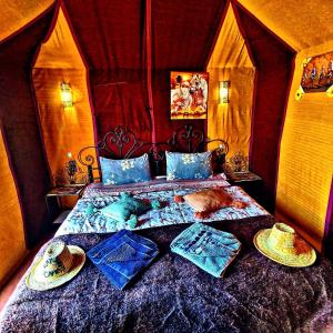 メルズーガにあるAppartement merzougaのベッドルーム(ベッド、帽子付)