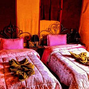 メルズーガにあるAppartement merzougaのベッドルーム1室(バナナ付きのベッド2台付)