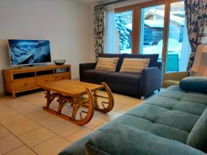 a living room with a couch and a table at Studio au pied de la télécabine, SaastalCards Saas-Fee in Saas-Fee
