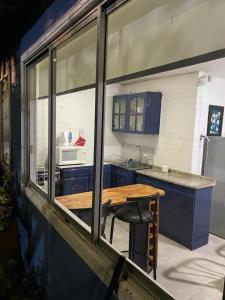 a kitchen with blue cabinets and a wooden table at casa Marcela papudo in Papudo