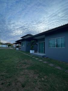 a blue house with a grass yard in front of it at Chalés em Flecheiras in Trairi