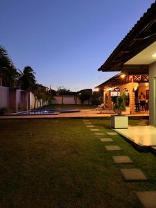 a backyard of a house with a grass yard at Chalés em Flecheiras in Trairi