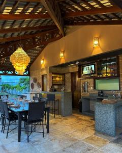 a restaurant with tables and chairs and a television at Chalés em Flecheiras in Trairi