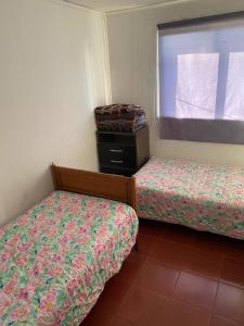 a small room with two beds and a window at casa Marcela papudo in Papudo