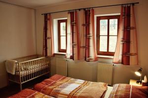 ein Schlafzimmer mit 2 Betten, einem Kinderbett und Fenstern in der Unterkunft Apartment U Lipna Nová Pec in Nová Pec
