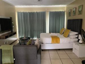 a living room with a bed and a couch at Grace Haven in Sandton +22 photos