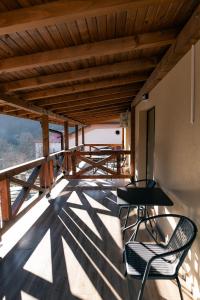 balcone con tavolo e sedie sul tetto di Къща за гости 'Кадийца' a Sushitsa