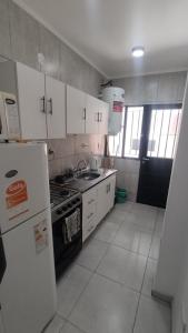 a kitchen with a stove and a refrigerator at Departamentos Amalia in Ciudad Lujan de Cuyo +10 photos