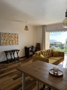 ein Wohnzimmer mit einer Couch und einem Tisch in der Unterkunft Manui Condo avec piscine et vue sur la mer et l'île de Moorea in Punaauia + 7 Fotos