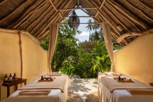 Dos camas en una habitación con ventana. en Zanzibar White Sand Luxury Villas & Spa - Relais & Chateaux, en Paje