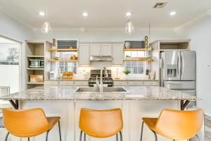 a kitchen with a large island with orange chairs at Sauna, Hot Tub and Cold Plunge Oklahoma City Home! in Oklahoma City