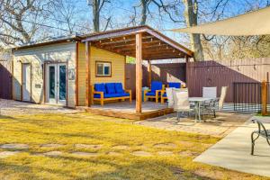a cabin with a deck with blue chairs and a table at Sauna, Hot Tub and Cold Plunge Oklahoma City Home! in Oklahoma City