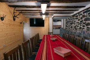 una sala da pranzo con tavolo e sedie rossi di Къща за гости 'Кадийца' a Sushitsa