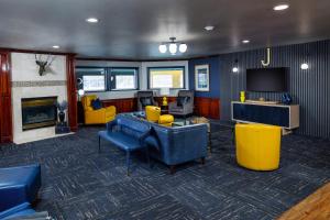 sala de estar con sillas azules y TV en Hotel J Green Bay, en Green Bay