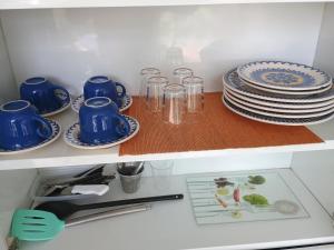 una cucina con piatti e stoviglie blu su uno scaffale di Refúgio na Floresta a Lavras Altre 9 foto