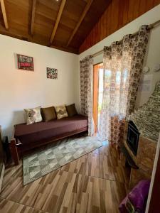 a living room with a couch and a fireplace at AP Temporada Monte Verde in Monte Verde