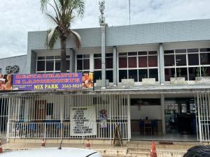 a building with a palm tree in front of it at Flat Esplêndido na Asa Sul in Brasilia