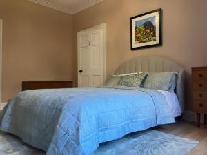 a bedroom with a bed with a blue comforter at Spacious Apartment in Central Edinburgh in Edinburgh
