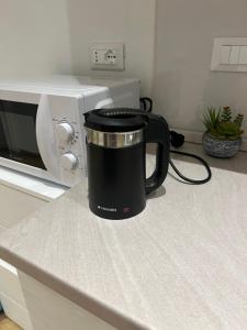 a black coffee pot sitting on a counter next to a microwave at Roma Cento new apartment in Rome