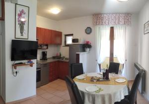 a kitchen and dining room with a table with chairs and a tableablish at Apartment Pino in Roč
