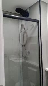 a glass shower door with a hairdryer at Studio 709 in Marília
