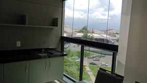 a kitchen with a large window with a view of a parking lot at Studio 709 in Marília