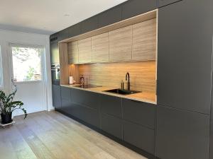 - une cuisine avec des placards noirs et un évier dans l'établissement Granåsen ski-VM, à Trondheim