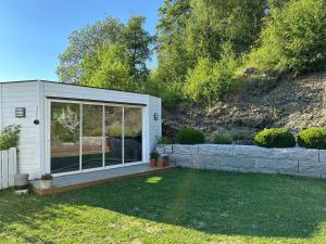 une petite maison avec une grande fenêtre dans une cour dans l'établissement Granåsen ski-VM, à Trondheim