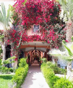 ein Haus mit rosa Blumen an der Seite in der Unterkunft Riad with Outdoor Swimming Pools in Marrakesch + 61 Fotos