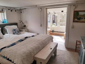 a bedroom with a large bed with a bench on it at Gezellig souterrain in bollestreek met prive ingang in Hillegom