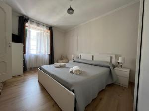 a white bedroom with a bed with towels on it at Appartamento Cavour in Ventimiglia