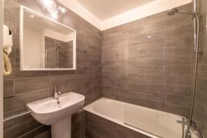 a bathroom with a sink and a bath tub at La Cigale Varoise - Hyères La Plage in Hyères