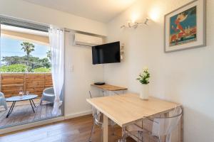 a living room with a table and a television at La Cigale Varoise - Hyères La Plage in Hyères