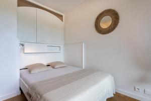a white bedroom with a bed and a mirror at La Cigale Varoise - Hyères La Plage in Hyères +23 photos