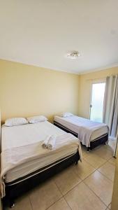 two beds sitting in a room with a window at Flutuante Hotel - Beira Mar in Serra +17 photos