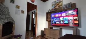 a flat screen tv on a stand in a living room at AP Temporada Monte Verde in Monte Verde