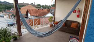 a hammock on the balcony of a house at AP Temporada Monte Verde in Monte Verde