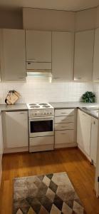 a kitchen with white cabinets and a stove top oven at Great apartment in Vantaa Close to the airport, with Sauna! in Vantaa