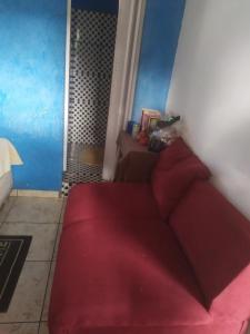 a red couch in a room with a shower at Lais in Lençóis