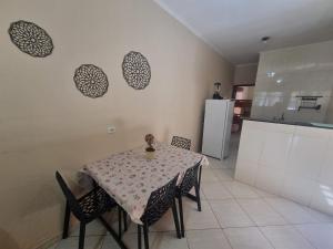 a kitchen with a table and chairs and a kitchen with a refrigerator at Kitnet Ramez in Três Lagoas +20 photos