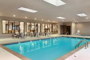 a pool at a hotel with tables and chairs at Wingate Slidell New Orleans in Slidell