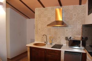 a kitchen with a sink and a stove at Ático de la Miel in Setenil