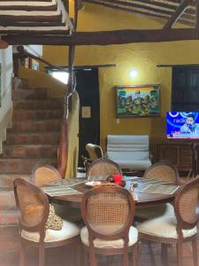 a dining room with a table and chairs and a television at Posada Altagracia San Gil in San Gil