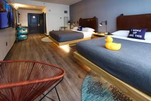 a hotel room with two beds and a chair at MOXY New Orleans Downtown/French Quarter Area in New Orleans