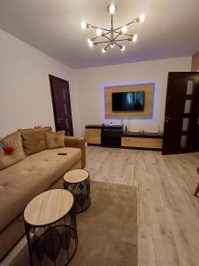 a living room with a couch and a flat screen tv at Cozy Place in Craiova