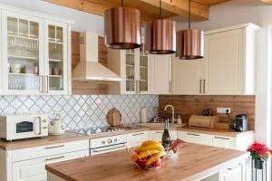 a kitchen with white cabinets and a wooden counter top at Chalet Laura in Stará Lesná